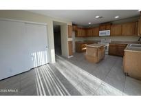 Spacious kitchen with oak cabinets, center island, and tile floors at 1352 S 221St Ln, Buckeye, AZ 85326