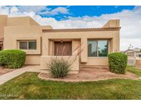 Welcoming desert home with an inviting front entrance and mature shrubbery enhancing its curb appeal at 14402 N 58Th Dr, Glendale, AZ 85306
