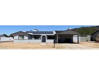 Charming single-story home featuring solar panels, covered parking, and low maintenance desert landscaping at 1550 W Willow Ave, Phoenix, AZ 85029