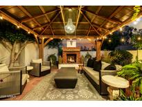 Cozy backyard patio with fireplace, seating, and chandelier lighting at 4833 N 38Th St, Phoenix, AZ 85018