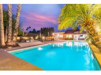 Inviting pool and patio area with palm trees and outdoor seating, perfect for relaxation at 10658 E Cinnabar Ave, Scottsdale, AZ 85258