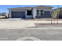 Beautiful single-story home featuring modern architecture, a well-kept yard and a two car garage at 22709 E Saddle Way, Queen Creek, AZ 85142