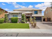 Elegant two-story home with a manicured lawn and a three-car garage in a suburban setting at 2496 E Lindrick Dr, Gilbert, AZ 85298