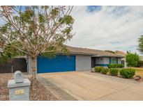 Charming single-story home featuring a blue garage door, a well-maintained lawn, and a mature shade tree at 620 W Crofton St, Chandler, AZ 85225