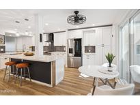 Bright updated kitchen with white cabinetry, stainless appliances, pendant lighting and an island with seating at 7214 N Via De La Siesta --, Scottsdale, AZ 85258