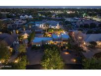 Aerial view of a well-lit property at dusk with landscaped grounds and neighboring homes at 8675 S College Ln, Tempe, AZ 85284