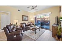 Inviting living room with comfortable leather seating and access to outdoor patio at 14950 W Mountain View Blvd # 7111, Surprise, AZ 85374