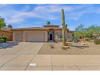 Beautiful single-story home showcasing desert landscaping, a three-car garage, and an inviting entrance at 15608 E Chaparral Way, Fountain Hills, AZ 85268