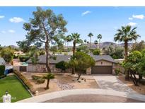Charming single-story home features a stone facade, mature landscaping, and a well-manicured front yard with palm trees at 211 W Braeburn Dr, Phoenix, AZ 85023