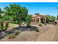 Stunning home features a grand entrance with stone columns and a beautifully landscaped front yard at 2300 E Sanoque Ct, Gilbert, AZ 85298