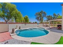 Backyard pool area with seating area and lush green grass at 2454 W Camp River Rd, Queen Creek, AZ 85144