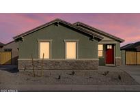 Charming single-story home with a red door and a well-maintained, low maintenance front yard at dusk at 2668 E San Miguel Dr, Casa Grande, AZ 85194