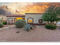 Charming home with desert landscaping, mature trees, and warm exterior lighting at 3001 E Winchcomb Dr, Phoenix, AZ 85032