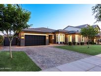 Charming single-story home featuring a two-car garage, paver driveway, manicured lawn and neatly trimmed landscaping at 3145 E Boot Track Trl, Gilbert, AZ 85296