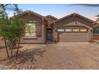 Charming single-Gathering home featuring a two-car garage, desert landscaping, and a welcoming front entrance at 4136 W Palace Station Rd, New River, AZ 85087