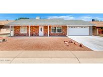 Charming single-story brick home featuring a well-manicured front yard and an attached two-car garage at 4310 E Sacaton St, Phoenix, AZ 85044