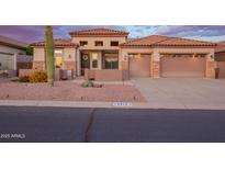 Beautiful beige home with a tile roof, 2-car garage, desert landscaping, and stone accents on the facade at 4615 S Primrose Dr, Gold Canyon, AZ 85118