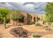 Inviting desert home showcasing stone accents, desert landscaping, and a brick pathway at 5690 E Canyon Creek Cir, Carefree, AZ 85377