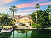 Waterfront home with pool, boat dock, lush landscaping, and gorgeous sunset views at 1507 E Treasure Cove Dr, Gilbert, AZ 85234
