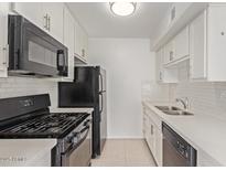 Bright kitchen features white cabinets, subway tile backsplash, and stainless steel appliances at 1701 W Tuckey Ln # 231, Phoenix, AZ 85015