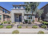 Contemporary two-story home featuring a modern facade, xeriscaped front yard, and decorative rock wall at 2024 W Trotter Trl, Phoenix, AZ 85085