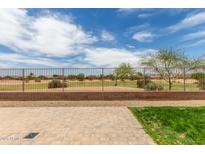 View of backyard with pavers, view fencing and golf course in the distance, under a sunny, partly cloudy sky at 21950 N Dietz Dr, Maricopa, AZ 85138