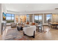 Bright living room featuring contemporary furnishings, eye-catching artwork, and expansive windows showcasing scenic views at 2211 E Camelback Rd # 1203, Phoenix, AZ 85016