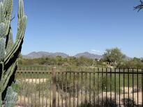 Scenic golf course view framed by a metal fence and desert landscape, mountains visible in the background at 22231 N 51St St, Phoenix, AZ 85054