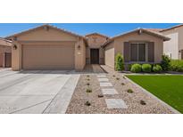 Charming single-story home featuring a well-manicured front yard and a two-car garage at 233 W Sweet Shrub Ave, San Tan Valley, AZ 85140