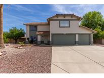 Charming two-story home featuring a well-maintained front yard and a spacious three-car garage at 2643 E Menlo St, Mesa, AZ 85213