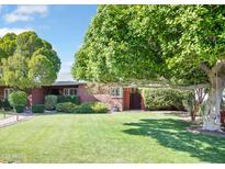 Charming brick home with a lush green lawn, mature trees, and well-maintained landscaping at 502 W Windsor Ave, Phoenix, AZ 85003