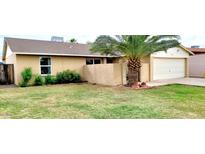 Charming single-story home with a tidy front lawn and mature palm tree at 5435 W Christy Dr, Glendale, AZ 85304