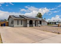 Charming home featuring a xeriscaped front yard, solar panels, and an inviting, arched entryway at 5702 S Beck Ave, Tempe, AZ 85283