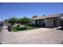 Pleasant single story home with manicured lawn, mature landscaping, and covered carport at 6725 W Cypress St, Phoenix, AZ 85035
