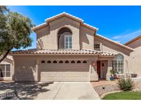 Inviting two-story home with a large, arched window, a three-car garage, and well-maintained landscaping at 13270 N 93Rd Way, Scottsdale, AZ 85260