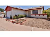 Charming single-story home with red trim, xeriscape landscaping, and a well-maintained lawn at 14235 N 26Th Dr, Phoenix, AZ 85023