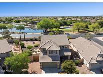 Beautiful aerial view of a two-story home with a lake nearby and well-maintained landscaping at 21019 N Sansom Dr, Maricopa, AZ 85138