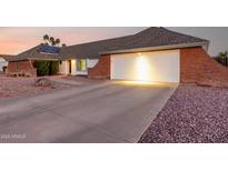 Charming single-story home with a brick accent, two-car garage and desert landscaping at 2259 E Ivy St, Mesa, AZ 85213