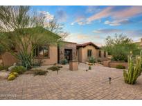 Charming single-story home with a brick-paved driveway and lush desert landscaping at 37440 N 104Th Pl, Scottsdale, AZ 85262