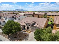 Charming single-Gathering home featuring a tile roof, mature trees, and a well-manicured front yard in a suburban neighborhood at 43998 W Palo Abeto Dr, Maricopa, AZ 85138