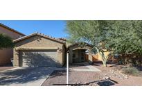Charming single-story home with a two-car garage, desert landscaping, and a mature shade tree at 7318 W St Charles Ave, Laveen, AZ 85339