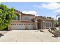 A beautiful two-story stucco home with a three-car garage and stone facade at 7340 W Bronco Trl, Peoria, AZ 85383