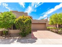 Charming home exterior showcasing desert landscaping, a two-car garage, and a private courtyard entrance at 7955 E Chaparral Rd # 141, Scottsdale, AZ 85250