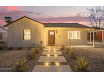 Charming house displaying its exterior lighting, carport, and desert-landscaped yard at 9042 N 3Rd Ave, Phoenix, AZ 85021