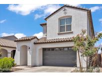 Inviting two-story home showcasing a gray garage door, covered front entry, and well-manicured landscaping at 9444 W Roma Ave, Phoenix, AZ 85037