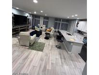 Spacious living room with modern decor, an open layout, and wood-look flooring at 9444 W Roma Ave, Phoenix, AZ 85037