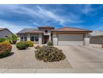 Charming single-story home featuring a red tile roof, two-car garage, and low-maintenance desert landscaping at 15976 W La Paloma Dr, Surprise, AZ 85374