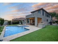 Exterior view of backyard showcasing a swimming pool, patio, and well-manicured lawn at 18515 N 97Th Way, Scottsdale, AZ 85255