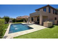 Backyard oasis with a sparkling pool, water features, and patio seating, perfect for outdoor entertaining and relaxation at 18515 N 97Th Way, Scottsdale, AZ 85255