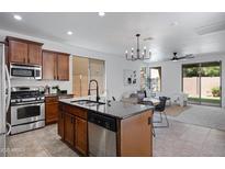 Modern kitchen boasts granite countertops, stainless steel appliances, and island with bar seating, seamlessly flowing into living spaces at 19172 E Kingbird Dr, Queen Creek, AZ 85142